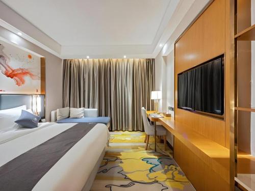a hotel room with a large bed and a desk at Green Tree Inn Zhuhai International Airport Huafa Shangdu in Zhuhai