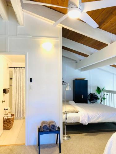 a bedroom with a white bed and a blue chair at Princeville Townhouse Apt - Views, Pool, Near Hanalei! in Princeville