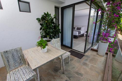 a wooden table and chairs on a patio with plants at Golden Bay Galapagos in Puerto Baquerizo Moreno