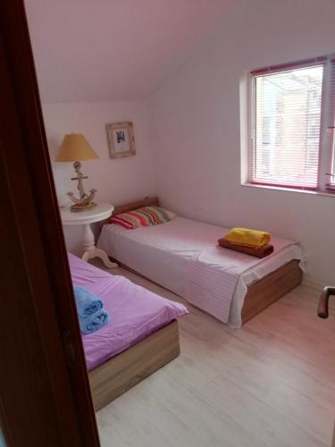 a bedroom with two beds and a table and a window at Sea view apartment in Tsarevo