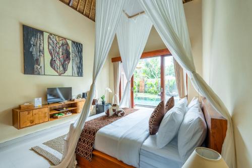 un dormitorio con una cama con mosquitera en Novancha Villa, en Ubud