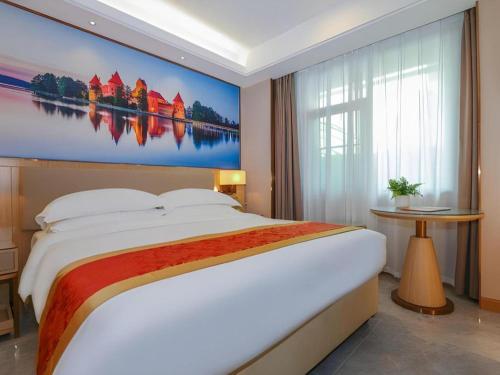 a bedroom with a large bed with a large painting on the wall at SHANGJINGHAO HOTEL （SAKATA SNOW ELEPHANT SUBWAY STATION SHOP） in Lung Wa