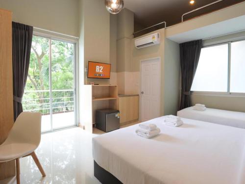 une chambre d'hôtel avec deux lits et une fenêtre dans l'établissement B2 Suan Luang Rama 9 Srinakarin 42 Boutique & Budget Hotel, à Bangkok