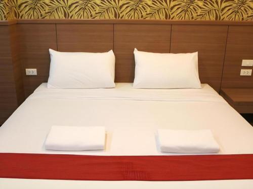 a bed with white sheets and two pillows at The Grace Residence in Surin