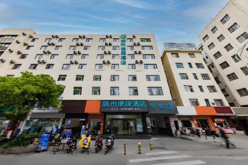 a large white building with people sitting outside of it at City Comfort Inn Kunming Dashuying Yejin Hospital Wangdaqiao in Kunming