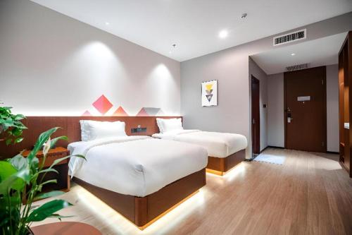 two beds in a hotel room with at Borrman Hotel Changzhi Medical College Wulong Campus High-speed Railway South Station in Changzhi