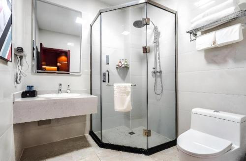 a bathroom with a shower and a toilet and a sink at Borrman Hotel Changzhi Medical College Wulong Campus High-speed Railway South Station in Changzhi