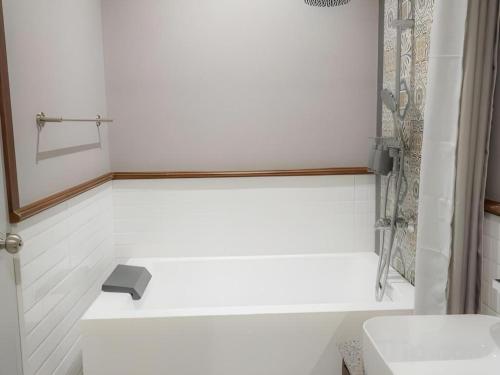 a white bathroom with a sink and a shower at My BanLao Hotel in Luang Prabang