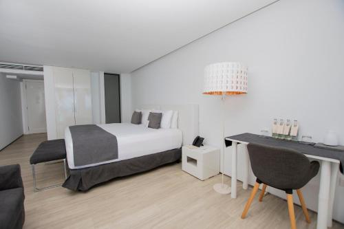 a bedroom with a bed and a table and chairs at Golden Bay Galapagos in Puerto Baquerizo Moreno