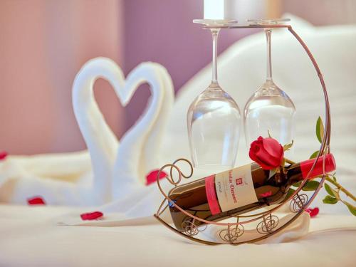 two wine glasses and a bottle and a rose at Lavande Hotel Changchun Gaoxin Jilin University in Changchun