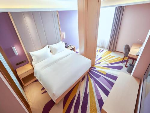 a hotel room with a bed and a desk and a room at Lavande Hotel Changchun Gaoxin Jilin University in Changchun