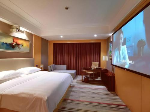 a hotel room with a large bed and a projection screen at Vienna Hotel Zhengzhou Exhibition Center Zhengbian Road in Zhengzhou