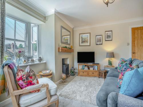 a living room with a couch and a tv at Halfehill Cottage in Richmond