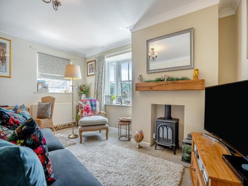 a living room with a blue couch and a fire place at Halfehill Cottage in Richmond