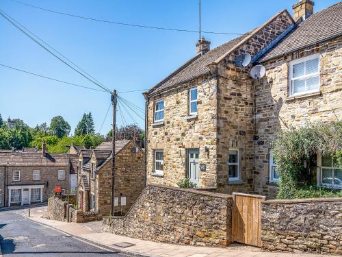 ein Steinhaus mit einer Steinmauer in der Unterkunft Halfehill Cottage in Richmond