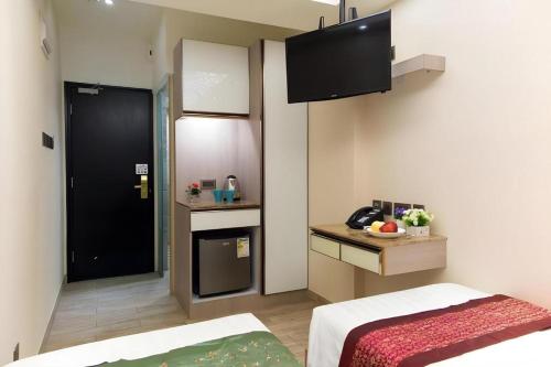 a small room with a bed and a kitchen at Metroplace Boutique in Hong Kong