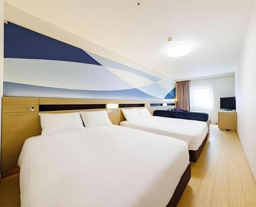 a hotel room with two beds and a television at Hotel Dream Gate Maihama in Chiba