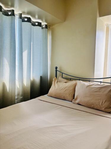 - un lit avec deux oreillers assis devant une fenêtre dans l'établissement Charming Iloilo City Condo for Rent - Entire House, à Iloilo