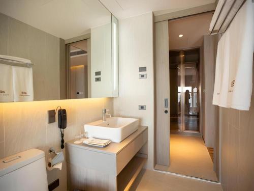 a white bathroom with a sink and a mirror at Symphony of The Sea Hotel in Ban Thai Don (2)