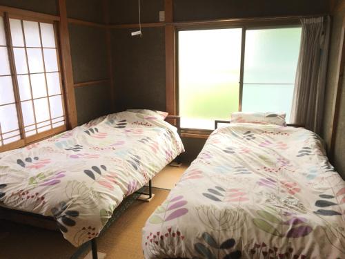 due letti in una stanza con due finestre di Everyone's house Nikko みんなの家日光 a Nikko
