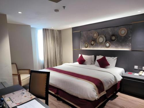 a bedroom with a large bed in a hotel room at Hermes Palace Hotel Medan in Medan