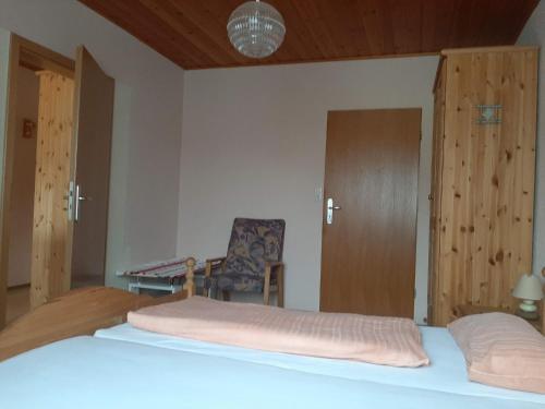 a bedroom with a bed and a chair and a desk at Pension Löffler in Steinbach am Wald
