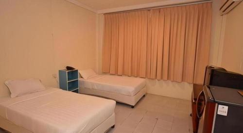 a hotel room with two beds and a television at Piyaporn Hill Paradise Hotel in Mae Sai
