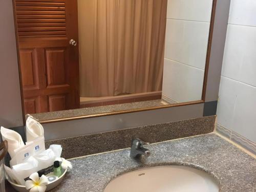 ein Badezimmer mit Waschbecken und Spiegel in der Unterkunft Supar Royal Beach Hotel in Ban Plau