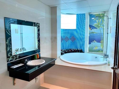 a bathroom with a large tub and a sink at Ha Oanh Hotel in Ho Chi Minh City