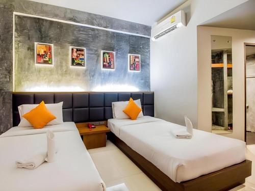 a bedroom with two beds and a laptop on a desk at B2 Thippanate Boutique & Budget Hotel in Chiang Mai