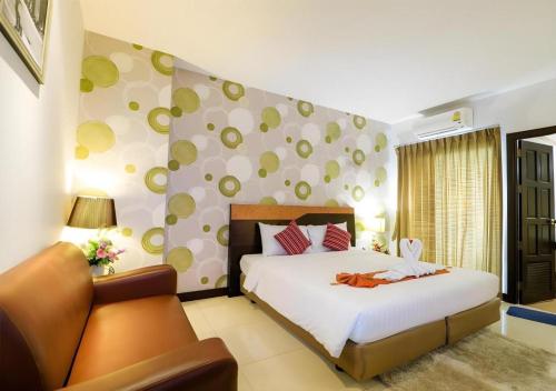 a bedroom with a large bed and a couch at G2 Hotel Group in Hat Yai