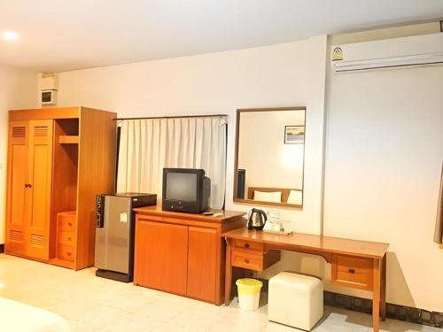 a room with a desk with a computer and a television at Krabi Grand Place Hotel in Ban Khlong Chi Lat