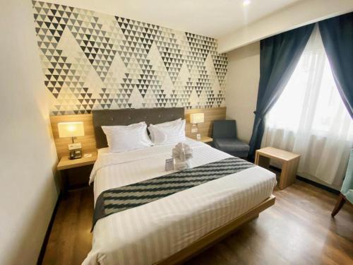 a hotel room with a bed with a teddy bear on it at Orchardz Hotel Gajah Mada in Pontianak