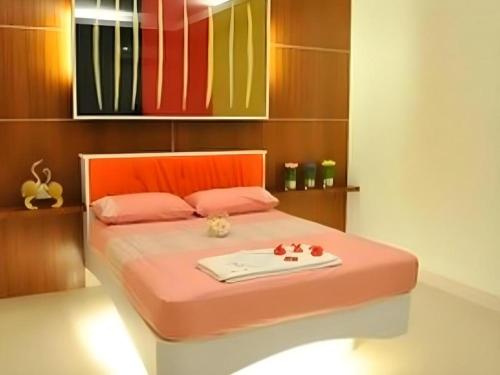 a bedroom with a pink bed with a tray on it at Chabakaew Resort in Tha Maka