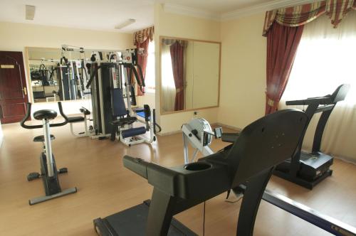 a gym with treadmills and exercise equipment in a room at Safeer Hotel Suites in Muscat