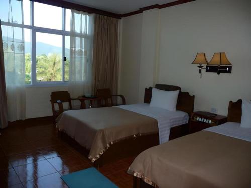 Postel nebo postele na pokoji v ubytování Dokchampa Hotel