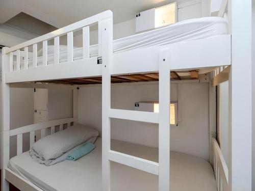 Una litera blanca en una habitación pequeña en Royal Hostel Singapore, en Singapur