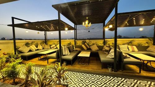 a patio with couches and tables on a deck at Boutique Apartments By One Tree in Jodhpur