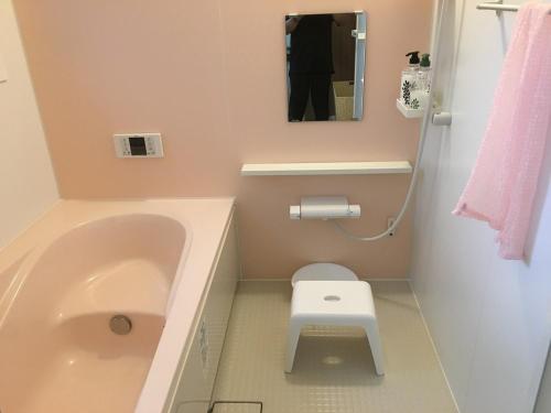 bagno con vasca, servizi igienici e specchio di Everyone's house Nikko みんなの家日光 a Nikko