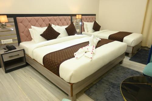 two beds in a hotel room with a toy rabbit on them at Hotel Kashi Crown in Varanasi