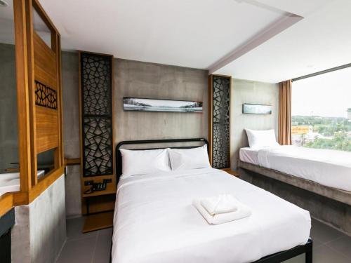 ein Schlafzimmer mit zwei Betten und einem großen Fenster in der Unterkunft B2 Khon Kaen Boutique & Budget Hotel in Khon Kaen