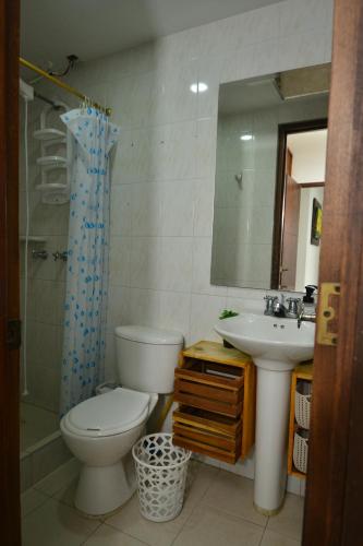 a bathroom with a toilet and a sink and a mirror at CASABLANCA, la calidez de tu hogar en Villeta in Villeta