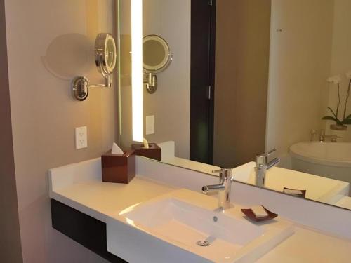 a bathroom with a sink and a large mirror at Luxury Suites International by Vdara in Las Vegas