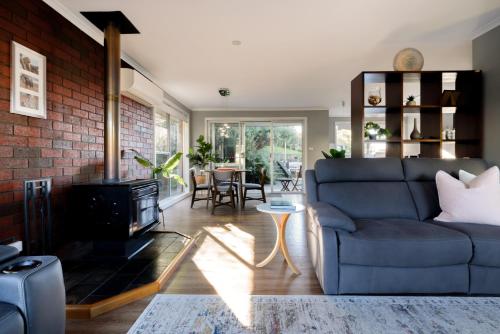 a living room with a couch and a fireplace at A Whole Lot Of House W/ Dual Living & Library in Inveresk
