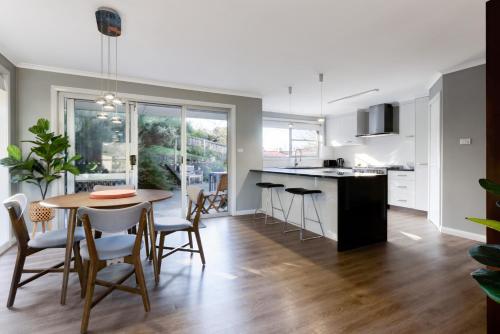 a kitchen and dining room with a table and chairs at A Whole Lot Of House W/ Dual Living & Library in Inveresk