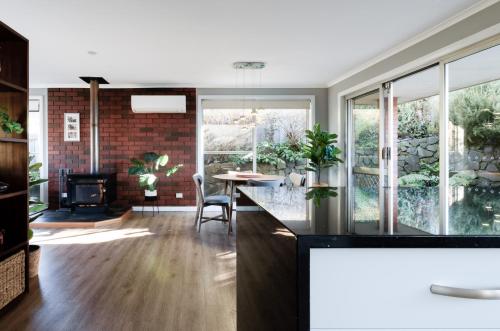 a kitchen and living room with a table and a fireplace at A Whole Lot Of House W/ Dual Living & Library in Inveresk