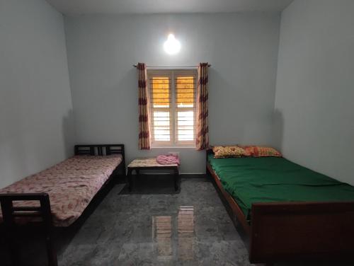 two beds sitting in a room with a window at Mountain View Stay in Kushālnagar