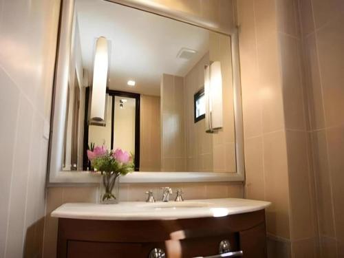 a bathroom with a sink and a large mirror at Lotusland Resort in Jomtien Beach