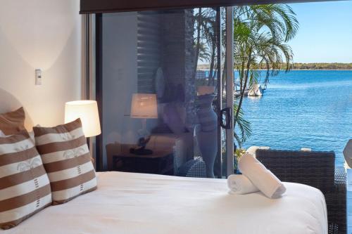 a bedroom with a bed with a view of the water at Waterfront Oasis in Runaway Bay - CoastHM in Gold Coast