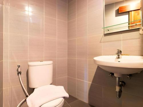 a bathroom with a toilet and a sink at Hadi Poetra Hotel in Kuta